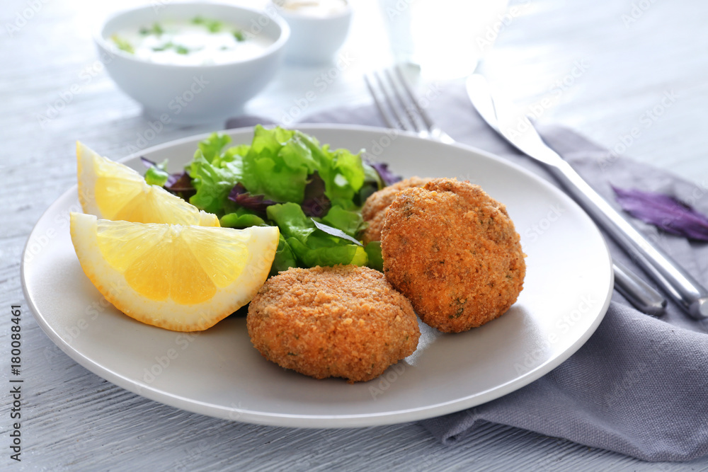 Plate with tasty salmon patties on table Plate with tasty salmon patties on table