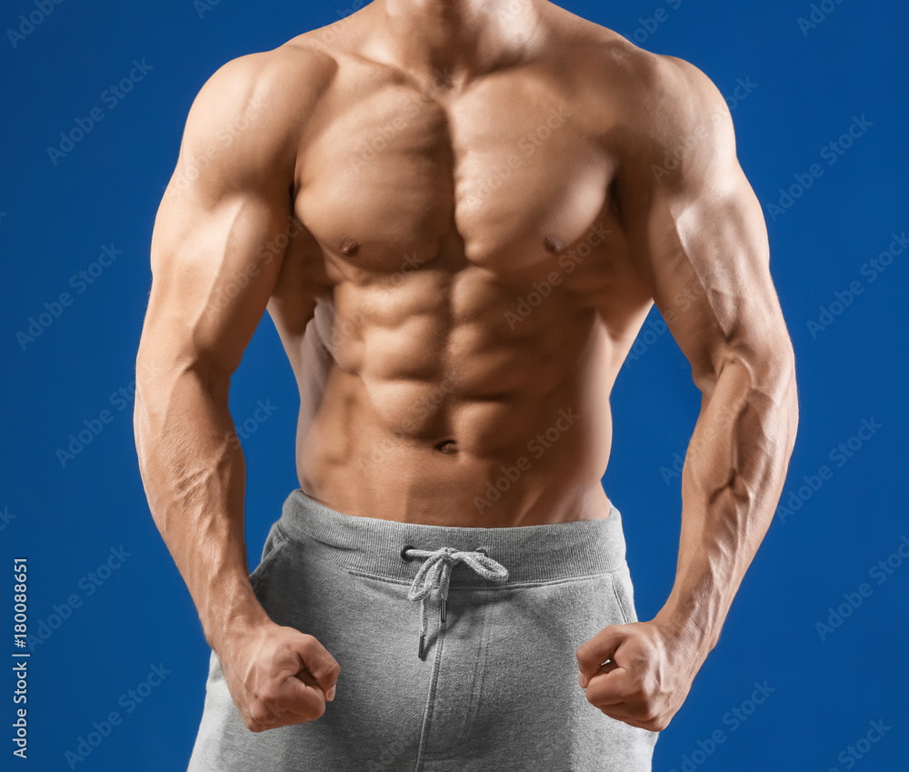 Muscular young man on color background
