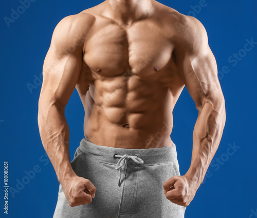 Muscular young man on color background