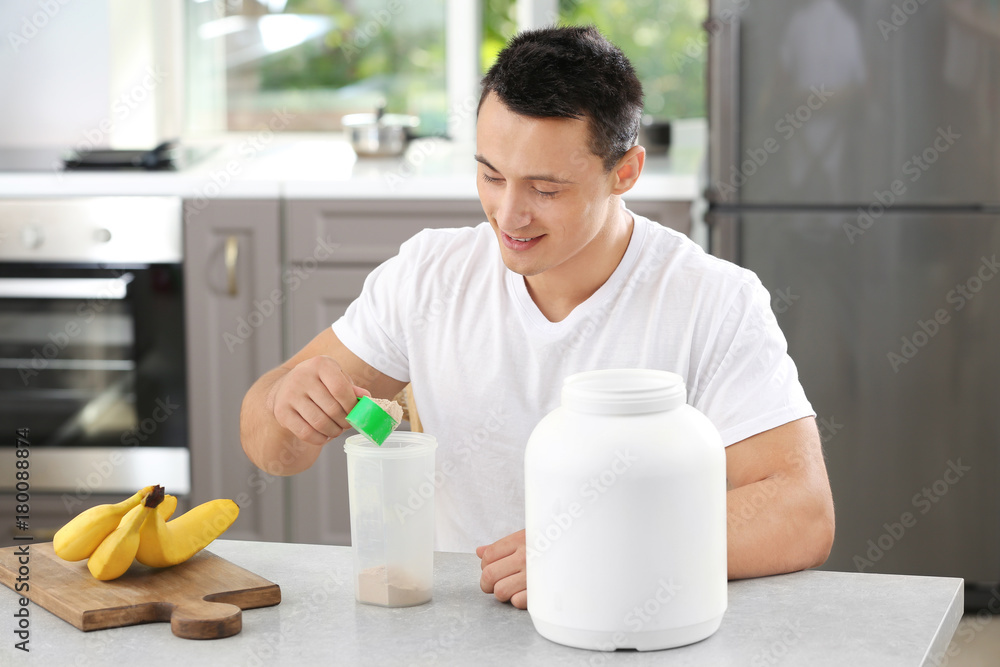 Young sporty man preparing protein shake at table Young sporty man preparing protein shake at table