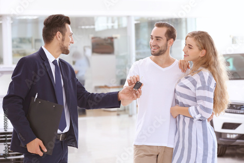 Car salesman giving key to ...