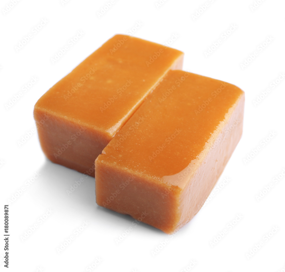 Delicious caramel candies on white background
