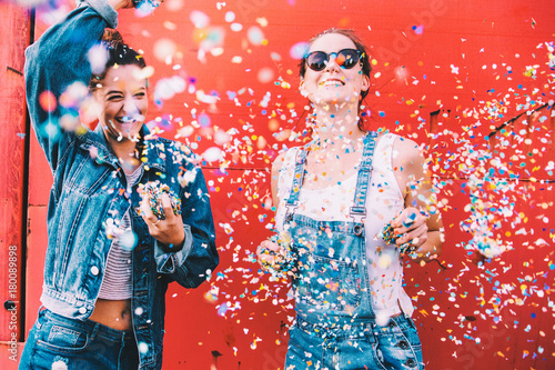Hipster girlfriends celebrating with confetti