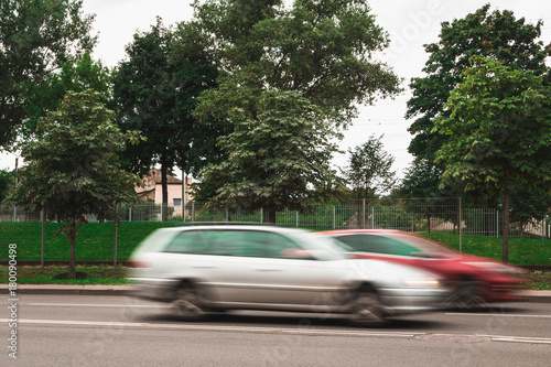 A red and white cars at high speed cross a pedestrian crossing, a motion blur effect. Street racing. © Jevgenij