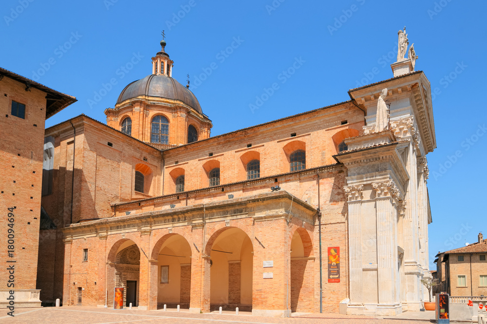 Urbino, Italy - August 9, 2017: The Cathedral. Piazza Duca Federico. Sculpture and statue in architecture.