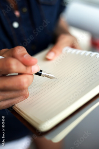 woman writing and taking note on notebook