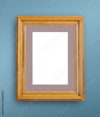 Mock up of blank photo frame on blue wall.