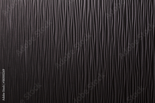 Wooden black undulating surface texture.