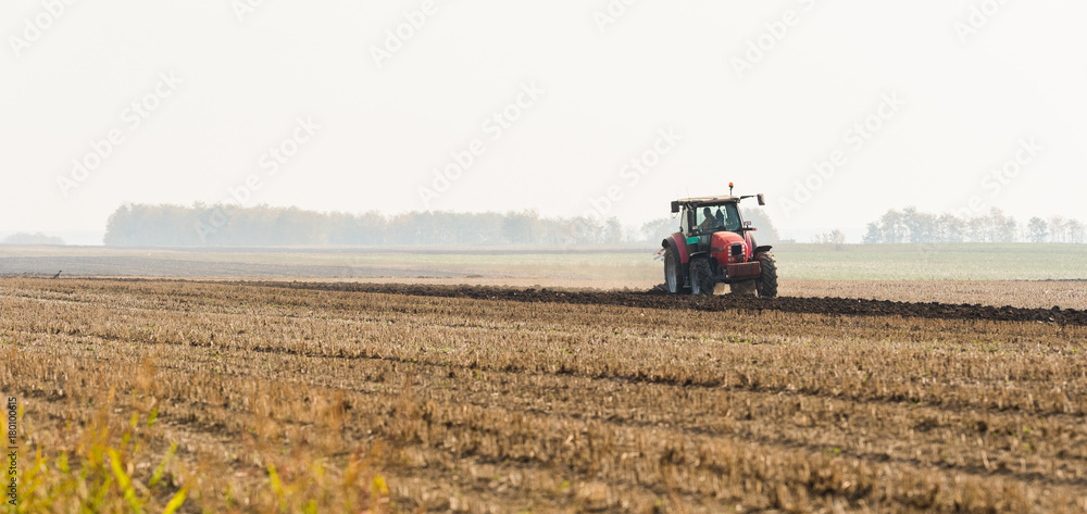 Tractor plowing fields -preparing land for sowing in autumn Tractor plowing fields -preparing land for sowing in autumn