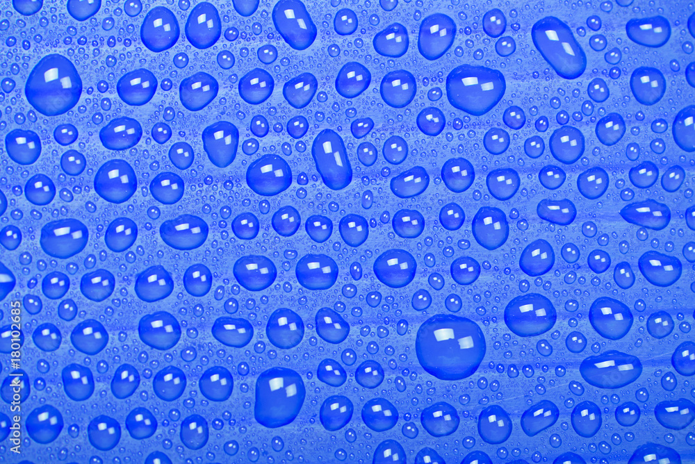 Abstract background of water droplets on blue surface.