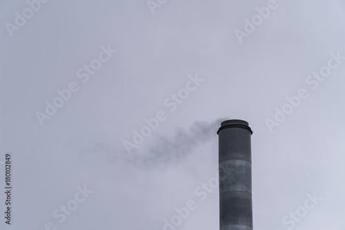 Pipe factory with smoke against the sky