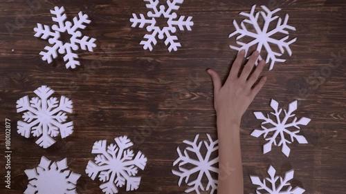 christmas decoration on wooden background with copy space for some text. female hands moving snowflakes photo