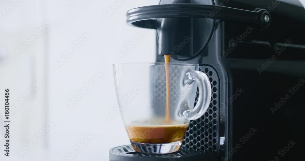 Espresso coffee being prepared by a small Nespresso machine