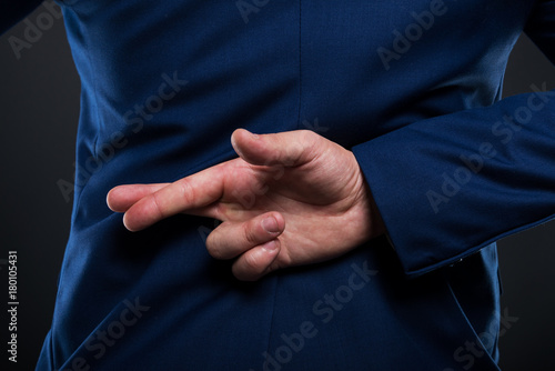 Obraz na plátne Closeup view of businessman standing with crossed fingers