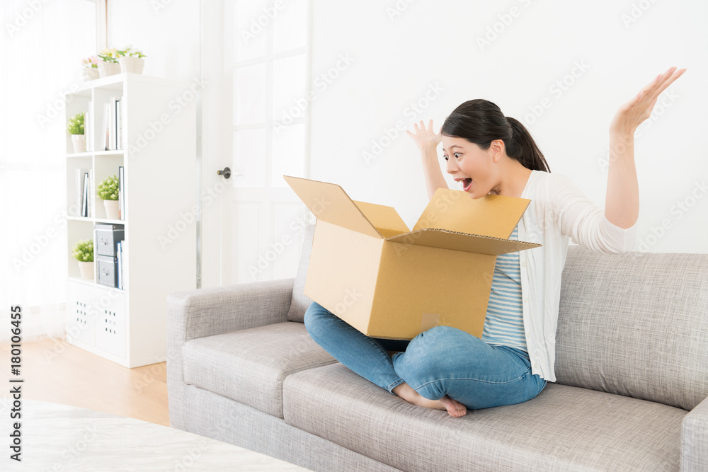 attractive girl sitting on sofa opening parcel box attractive girl sitting on sofa opening parcel box