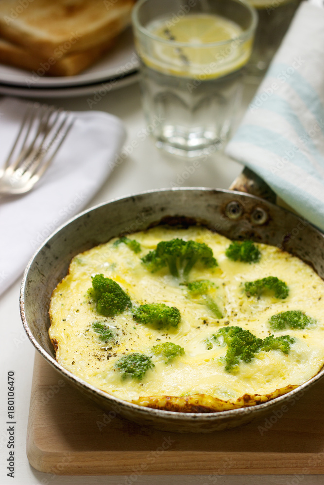 Omelette with broccoli and cheese served with bread toasts and lemonade.