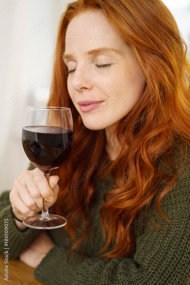 frau genießt ein glas rotwein mit geschlossenen augen frau genießt ein glas rotwein mit geschlossenen augen