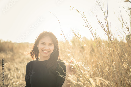 Close up sad beautiful asian woman from unrequire love in the grass flowers field,she think so much about boyfriend,life without love,vintage style,dark tone photo