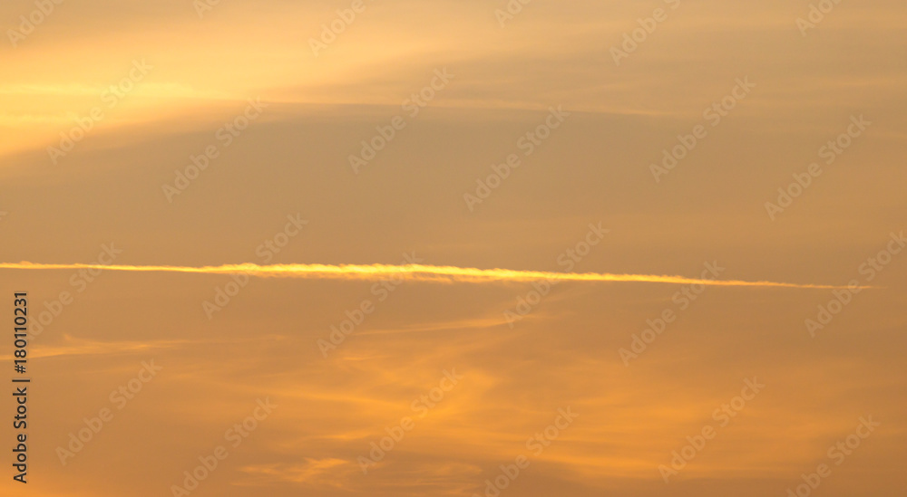 Fototapeta premium trail from the plane in the sky at sunset