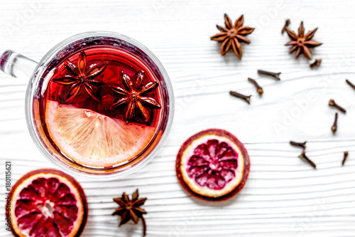 mulled wine with spices in cup wooden background top view