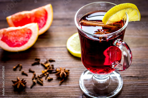 mulled wine with spices in cup on wooden background