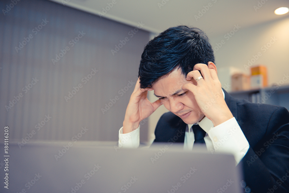 Businessman stress from hard work on the desk at office dark tone Businessman stress from hard work on the desk at office dark tone