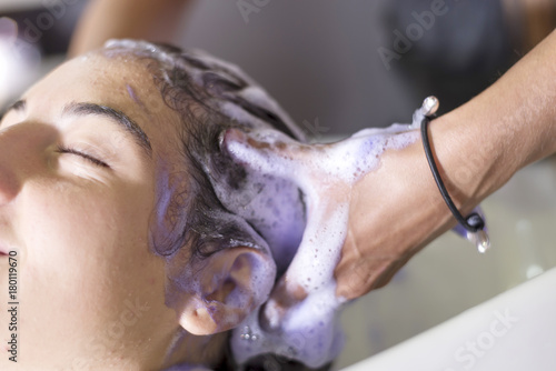 Young woman washing hair in salon