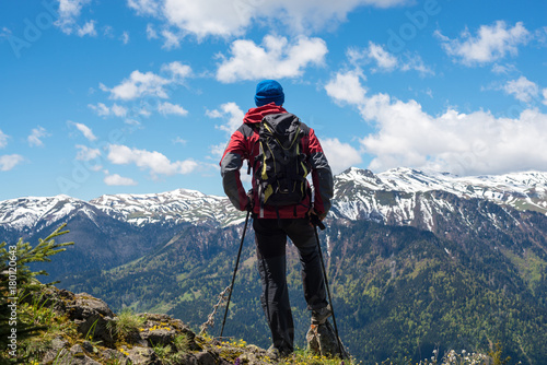 Adventurer, with backpack, stands on the mountain top