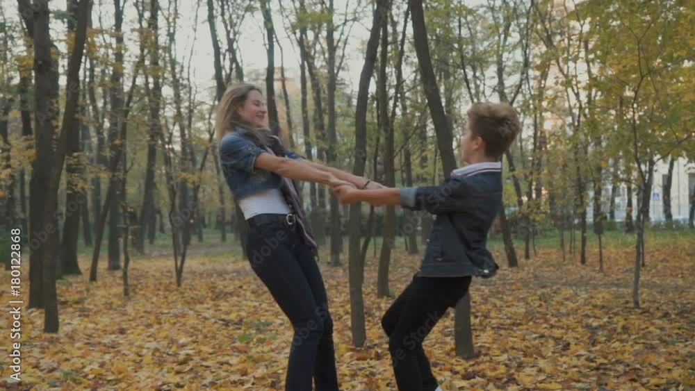 Happy mother and son turns around in autumn forest Happy mother and son turns around in autumn forest