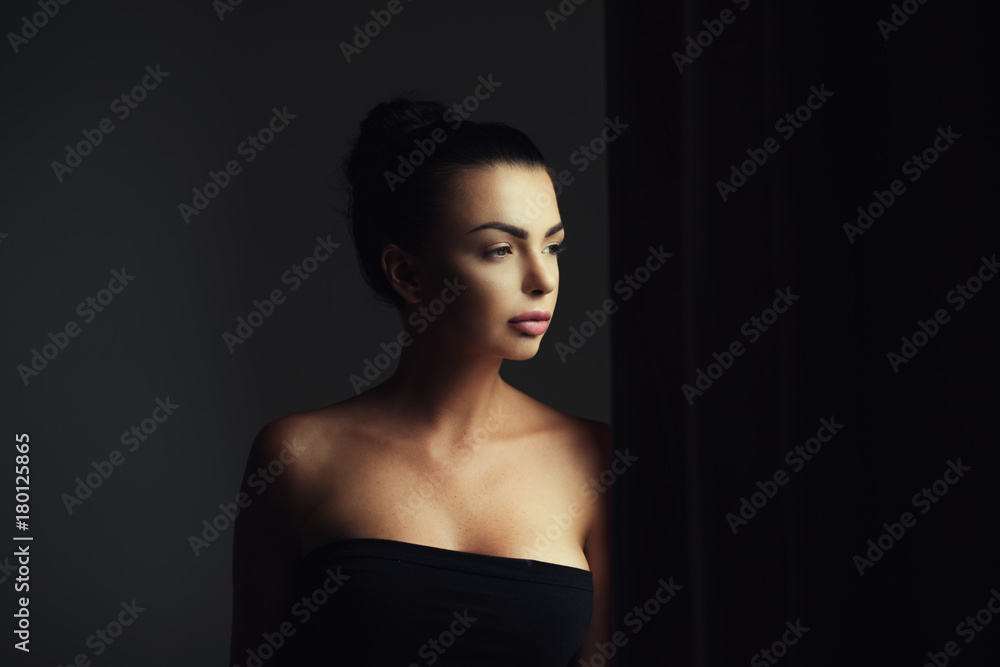 Portrait of a woman standing in darkness Portrait of a woman standing in darkness