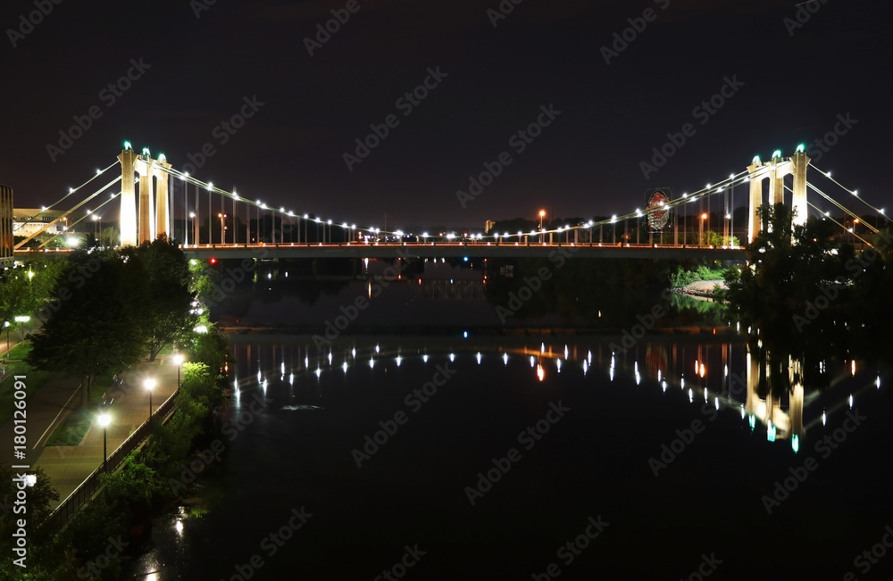 City of Minneapolis night view with glowing in the dark Hennepin Avenue bridge over Mississippi river. Bridges of Minneapolis. Travel America background. Midwest USA, Minnesota.