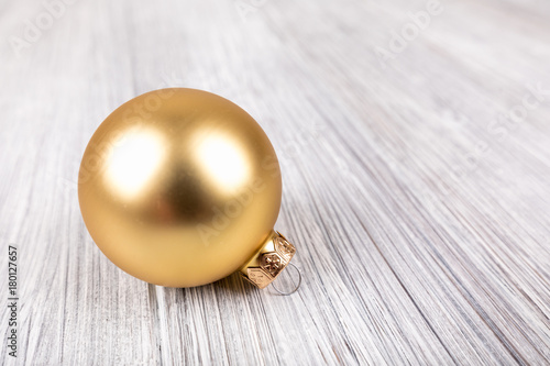 gold christmas ball on a white wooden background