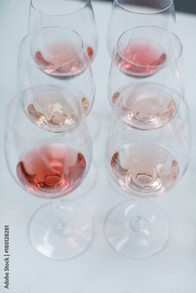 Row of glasses with white and rose wines prepared for tasting Row of glasses with white and rose wines prepared for tasting