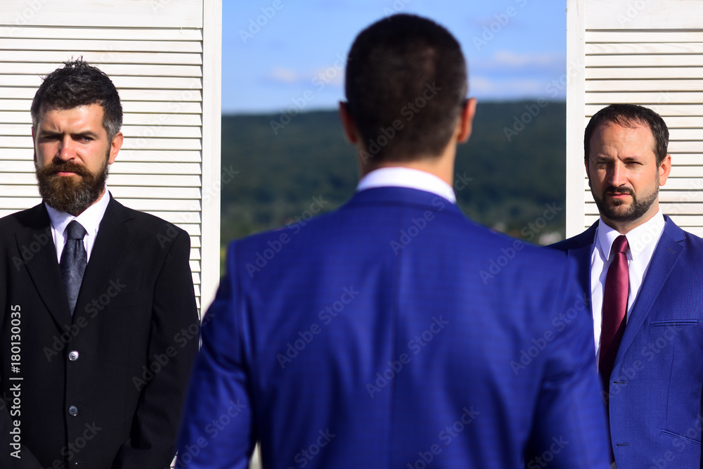Businessmen wear smart suits and ties on wooden wall Businessmen wear smart suits and ties on wooden wall