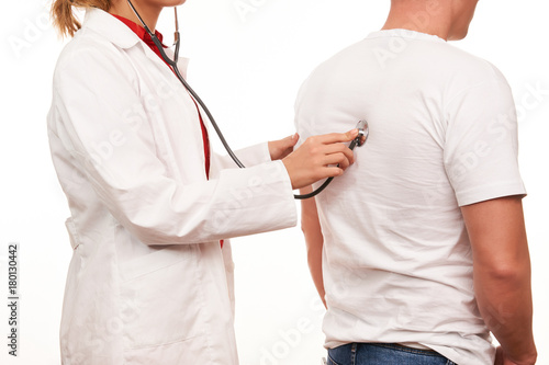 Female doctor with a medical stethoscope, listening a patient heartbeat