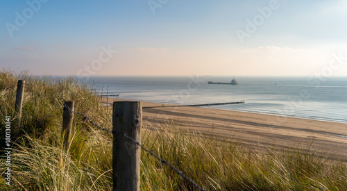 Beach with dunes at daytime. Beautiful dreamy shot of the endless sea in Zoutelande, Netherlands photo