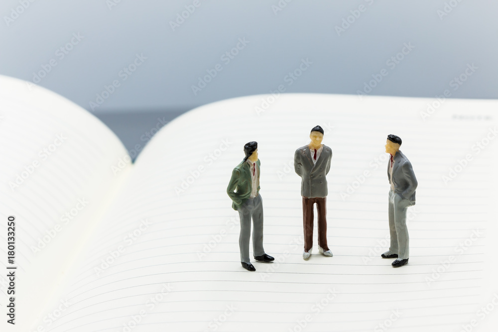 Miniature people: small figures businessmen stand on Blank Notebook can copy space and using as background business team competition concept.
