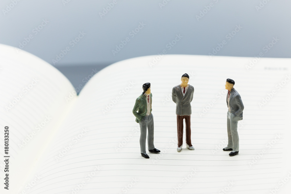 Miniature people: small figures businessmen stand on Blank Notebook can copy space and using as background business team competition concept. Miniature people: small figures businessmen stand on Blank Notebook can copy space and using as background business team competition concept.