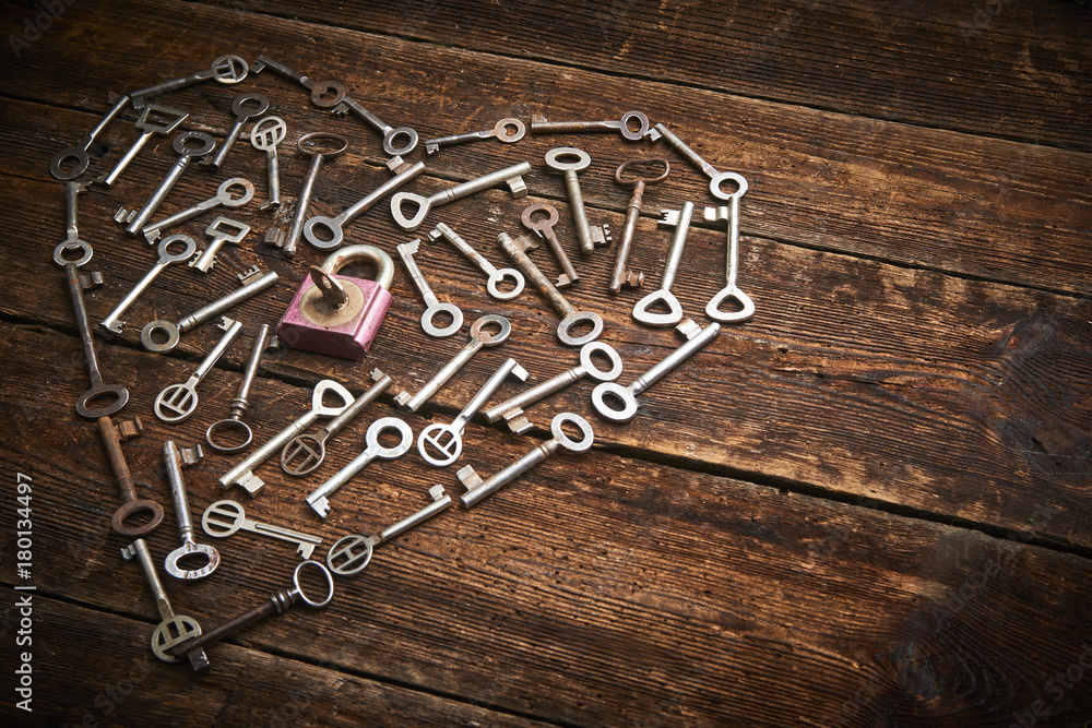 Old keys in a heart shape, on a wood surface, vintage look Old keys in a heart shape, on a wood surface, vintage look