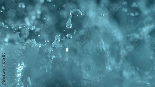 Blue and clean ice breaking in slow motion on black