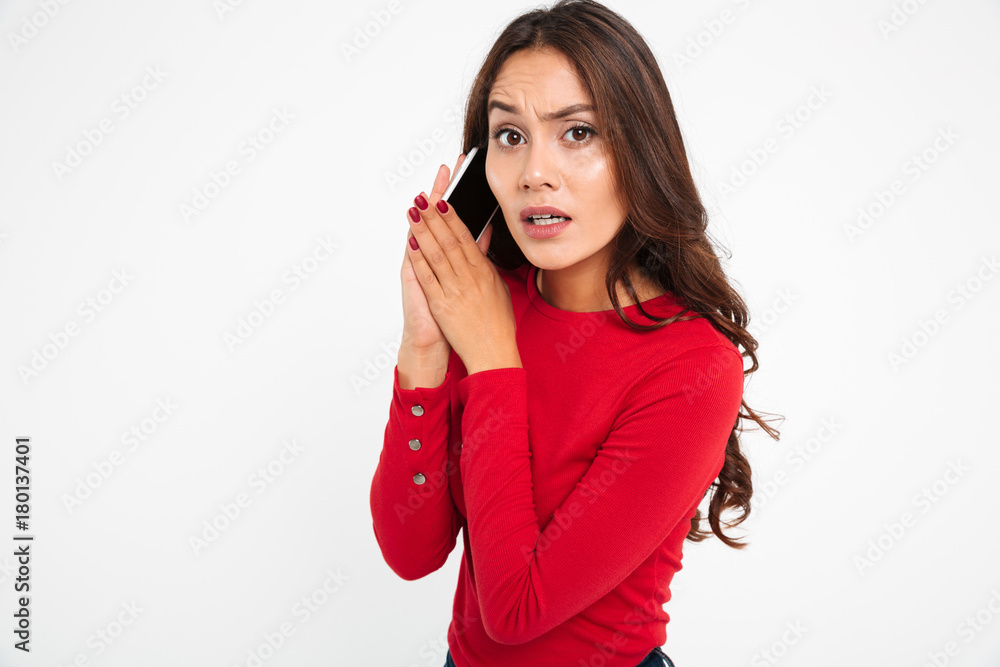 Portrait of a confused asian woman covers mobile phone Portrait of a confused asian woman covers mobile phone