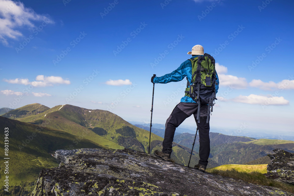 Hiker outdoor with equipment on mountain rock, nature mountain exploring, hiking and trekking