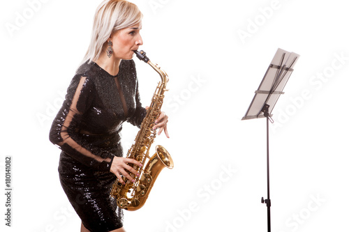 Gorgeous saxophonist woman playing at her musical instrument. Isolated over white background in studio photo