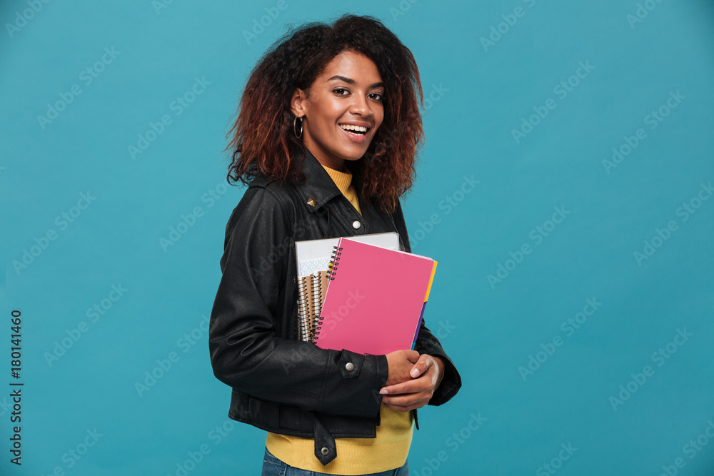 Happy beautiful young african woman student holding notebooks. Happy beautiful young african woman student holding notebooks.