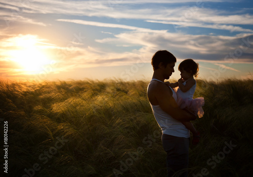 Dad and daughter on a sunset field