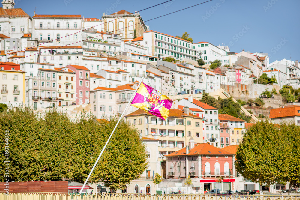 Fototapeta premium Cityscape view on the old town of Coimbra city with flag in the central Portugal