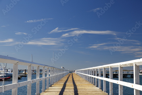 Fototapeta Perspective view of a wooden pier on the ocean
