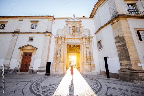 View on the main entrance to the courtyard of the old university building with woman walking in Coimbra city in the central Portugal