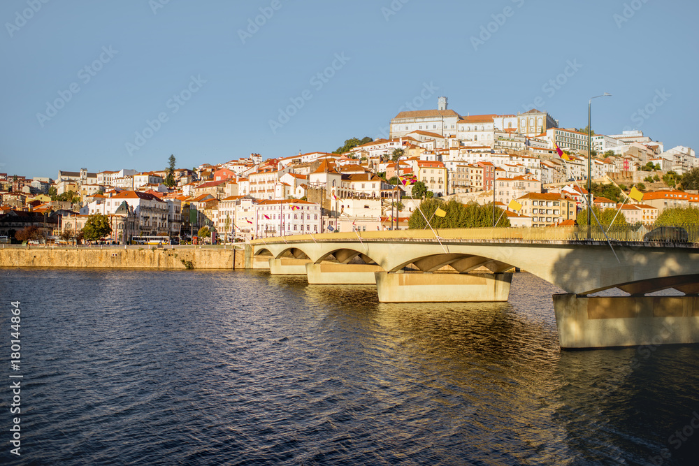 Cityscape view on the old town of Coimbra city with Mondego river and bridge during the sunset in the central Portugal