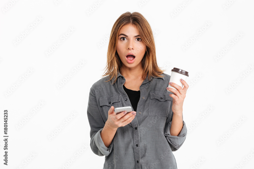 Portrait of a shocked pretty girl holding mobile phone Portrait of a shocked pretty girl holding mobile phone
